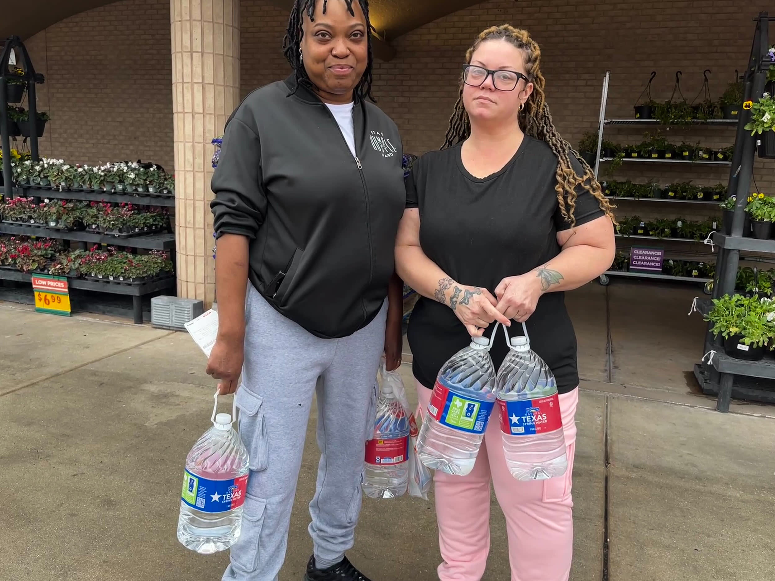 Nu Riley and Scarlet Riley hold water bottles outside of shopping center.