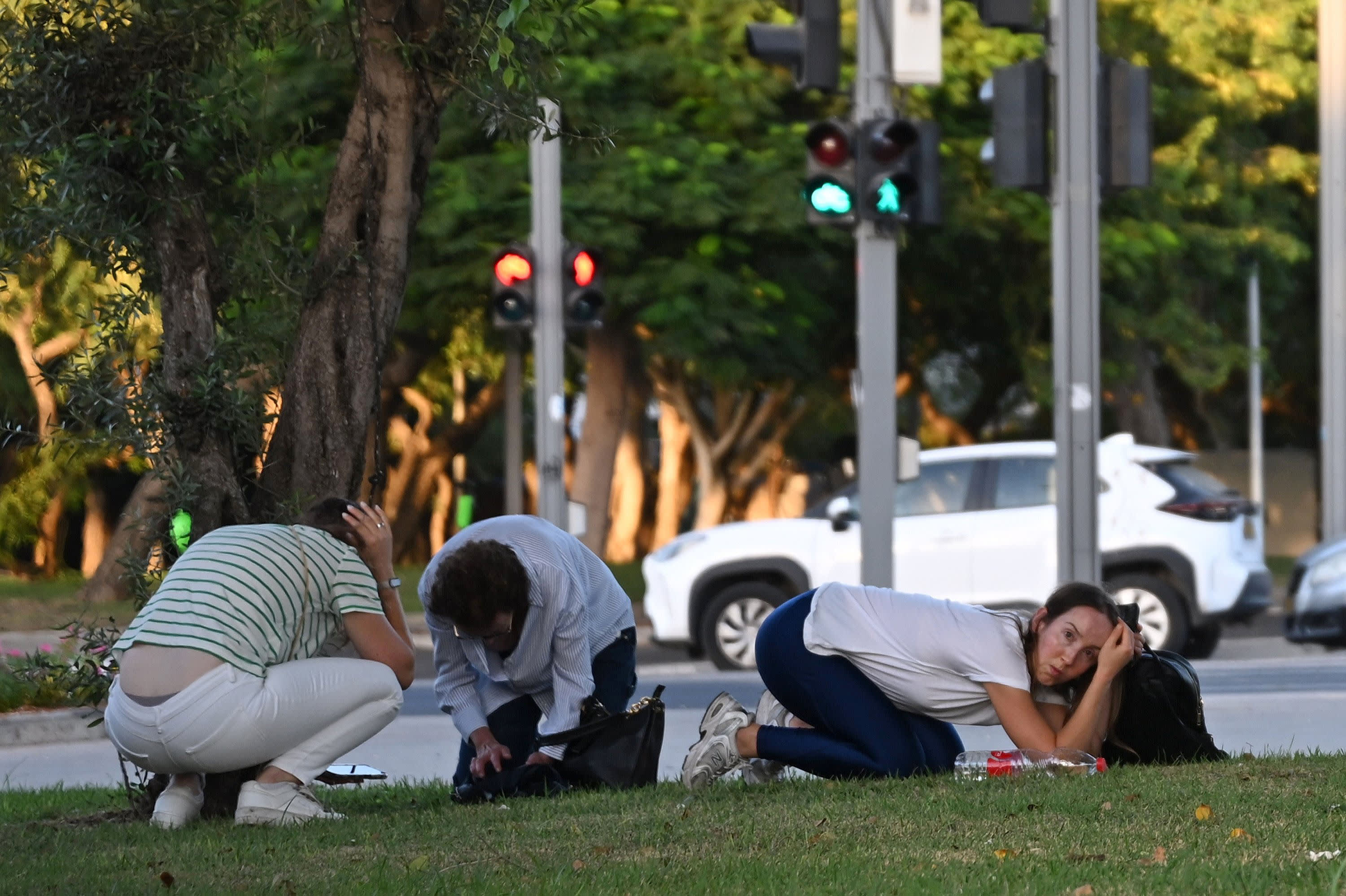 People take cover during a red alert siren which the IDF confirmed was a surface to surface missile fired from Yemen and intercepted on Oct. 7, 2024 in Nir Oz, Israel.