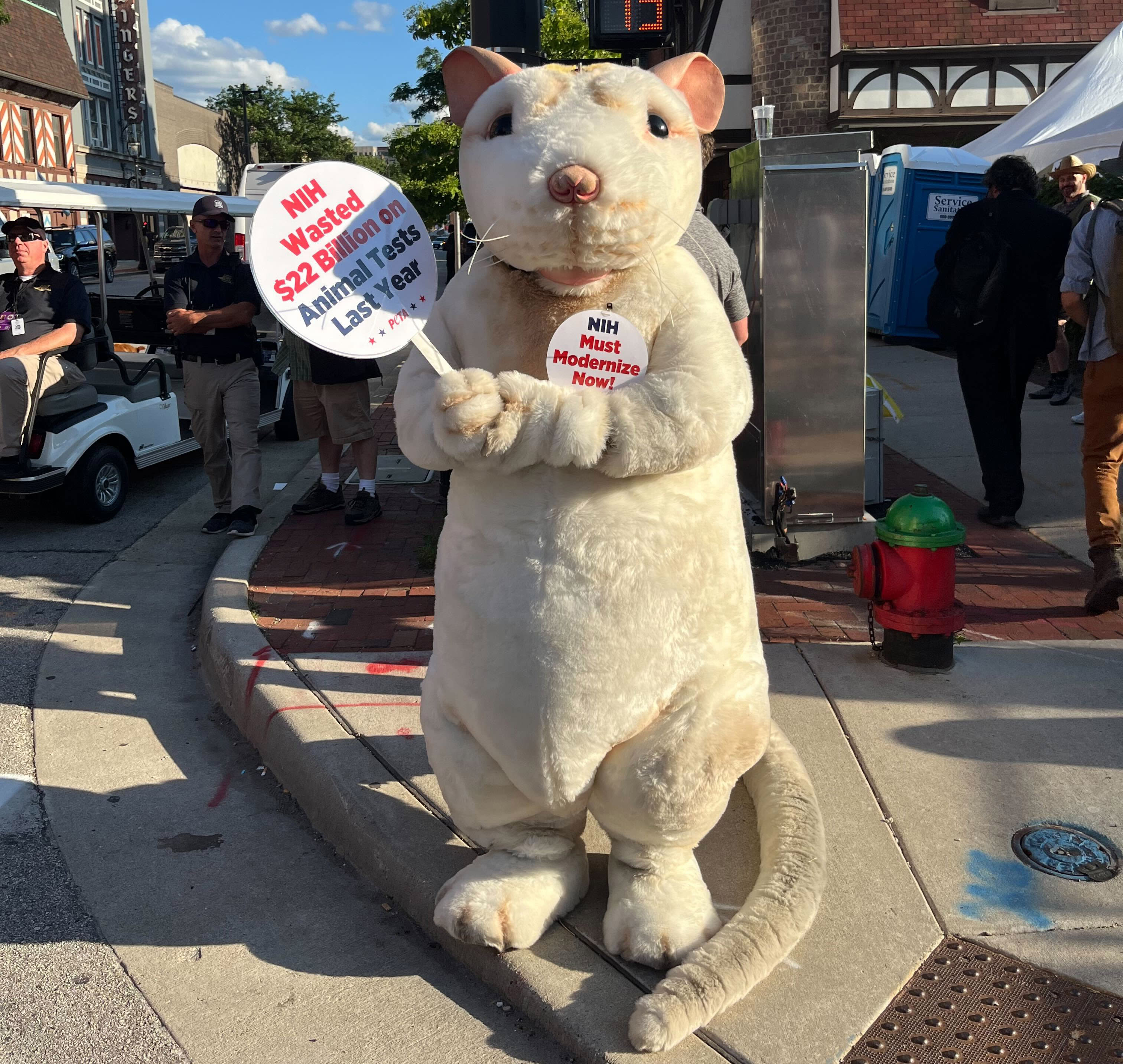 A person in a rat costume protests animal testing outside security at the Fiserv Forum in Milwaukee.