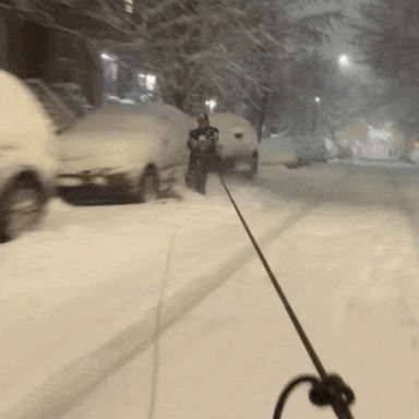A man on skis is towed by a car in Brooklyn, N.Y., on Feb. 22, 2026.