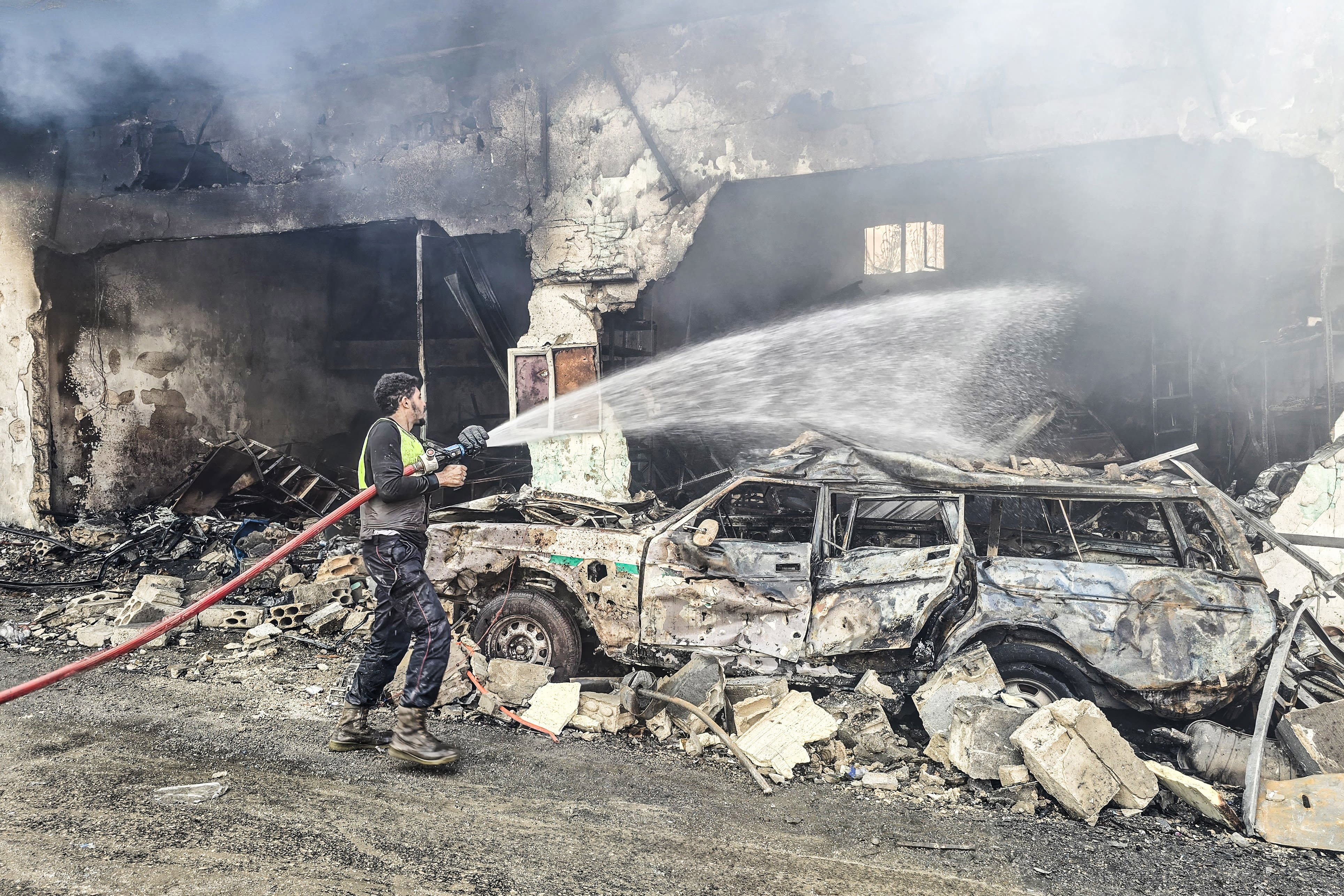 A firefighter extinguishes a fire at the site of an Israeli airstrike in the southern Lebanese village of Hanouiyeh, east of Tyre, on March 30, 2026. 