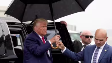 Walt Nauta holds umbrella for Trump after arraignment