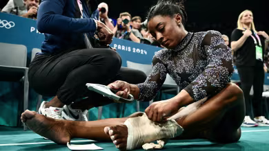 Biles battles through calf pain to push U.S. into the lead