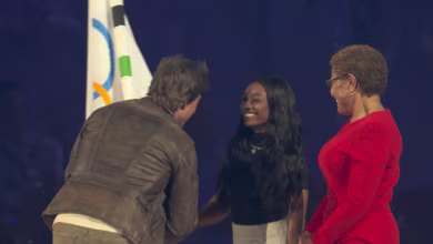 Simone Biles, Karen Bass hand Olympic flag to Tom Cruise