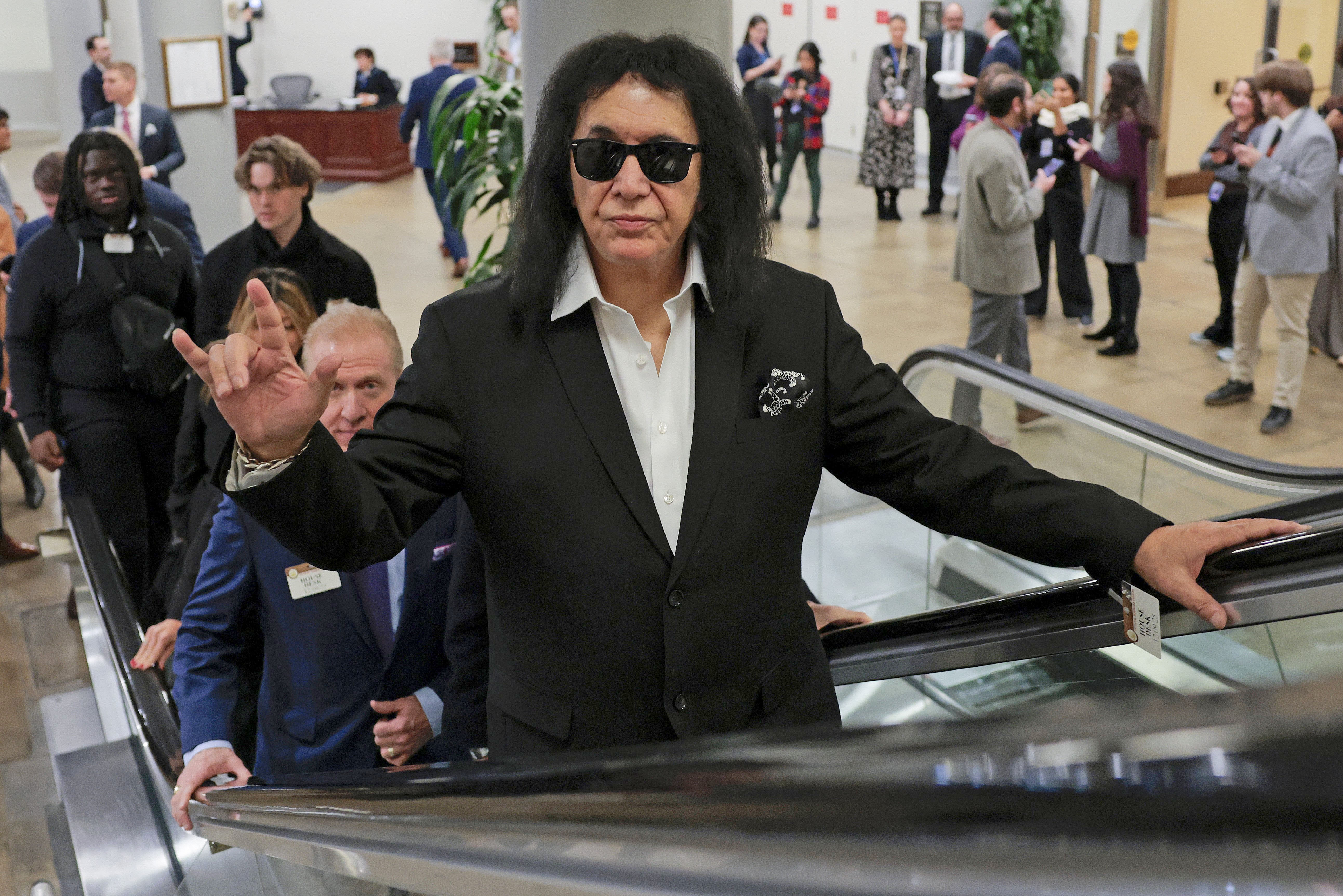 Gene Simmons flashes the sign of the horns as he walks through the Capitol 