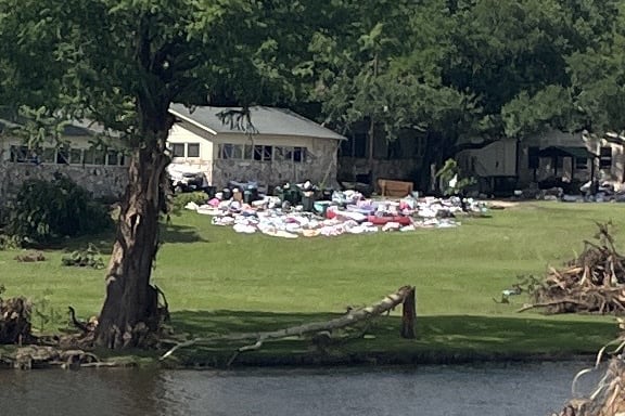 Children's belongings piled up outside buildings at Camp Mystic.
