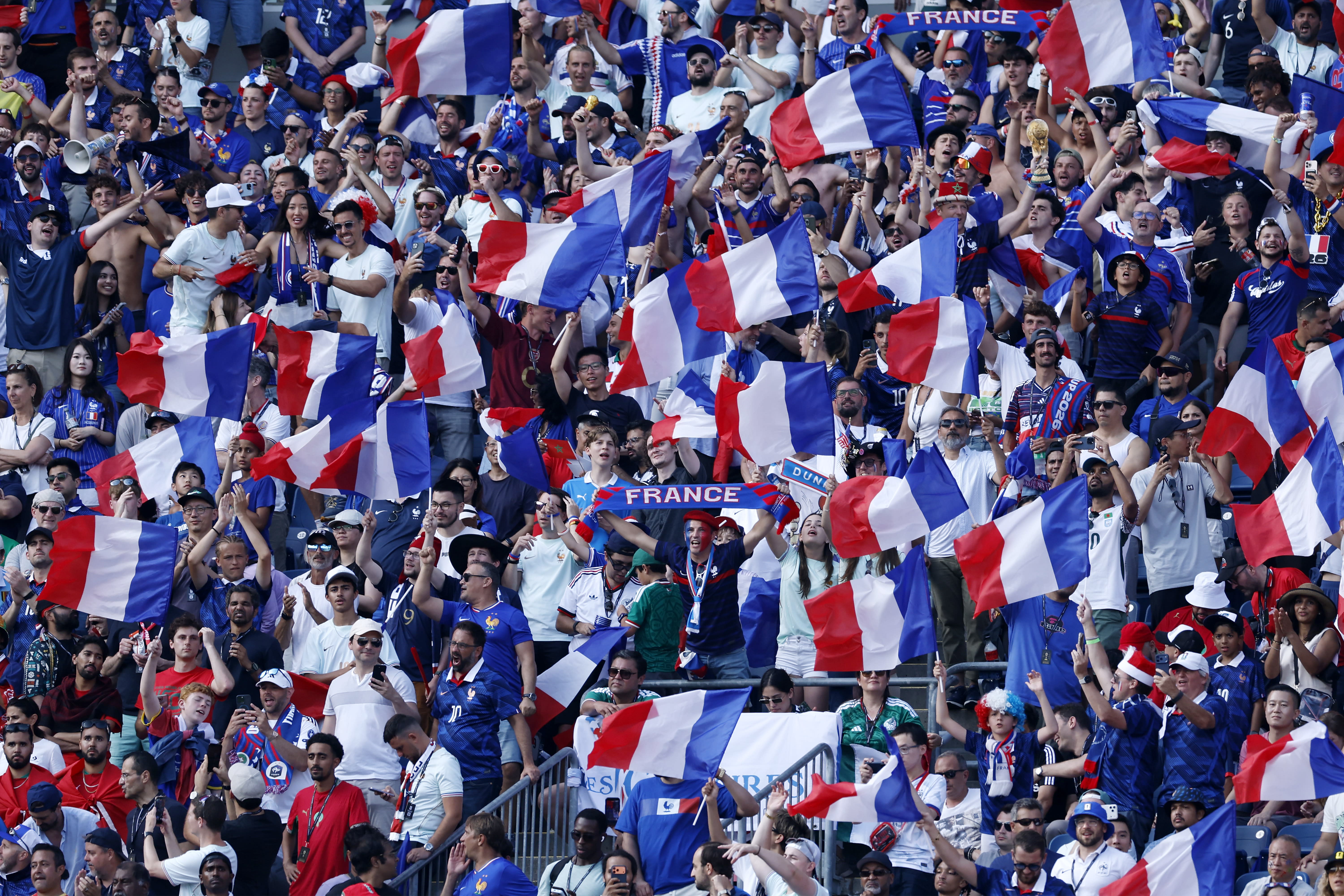 France soccer fans waving the national flag in the stands.