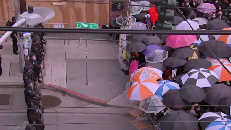 Seattle protesters use umbrellas to guard against possible pepper spray