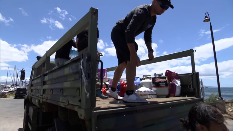 Volunteers shout traditional Hawaiian chant as they load supplies for those hurt by fires