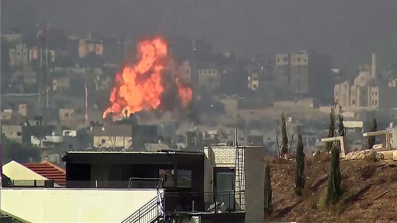 Videos show a huge explosion in Gaza and streaks of rockets launched towards Israel