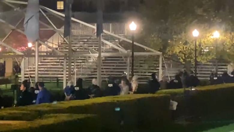 Police seen moving protesters away from Hamilton Hall, hands appearing to be tied