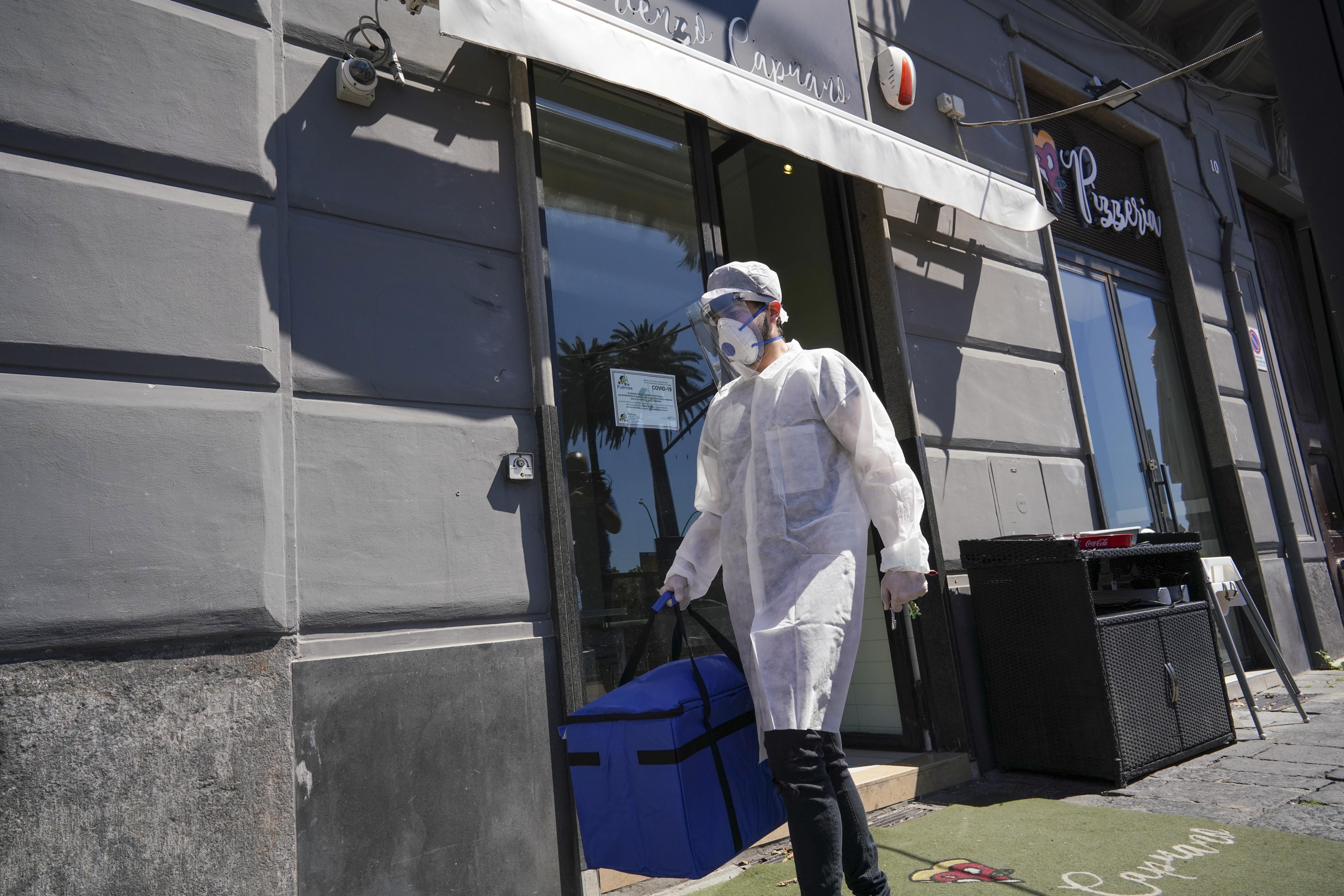 Image: A man carries pizza for home delivery at the Caputo pizzeria in Naples, Italy on Monday.