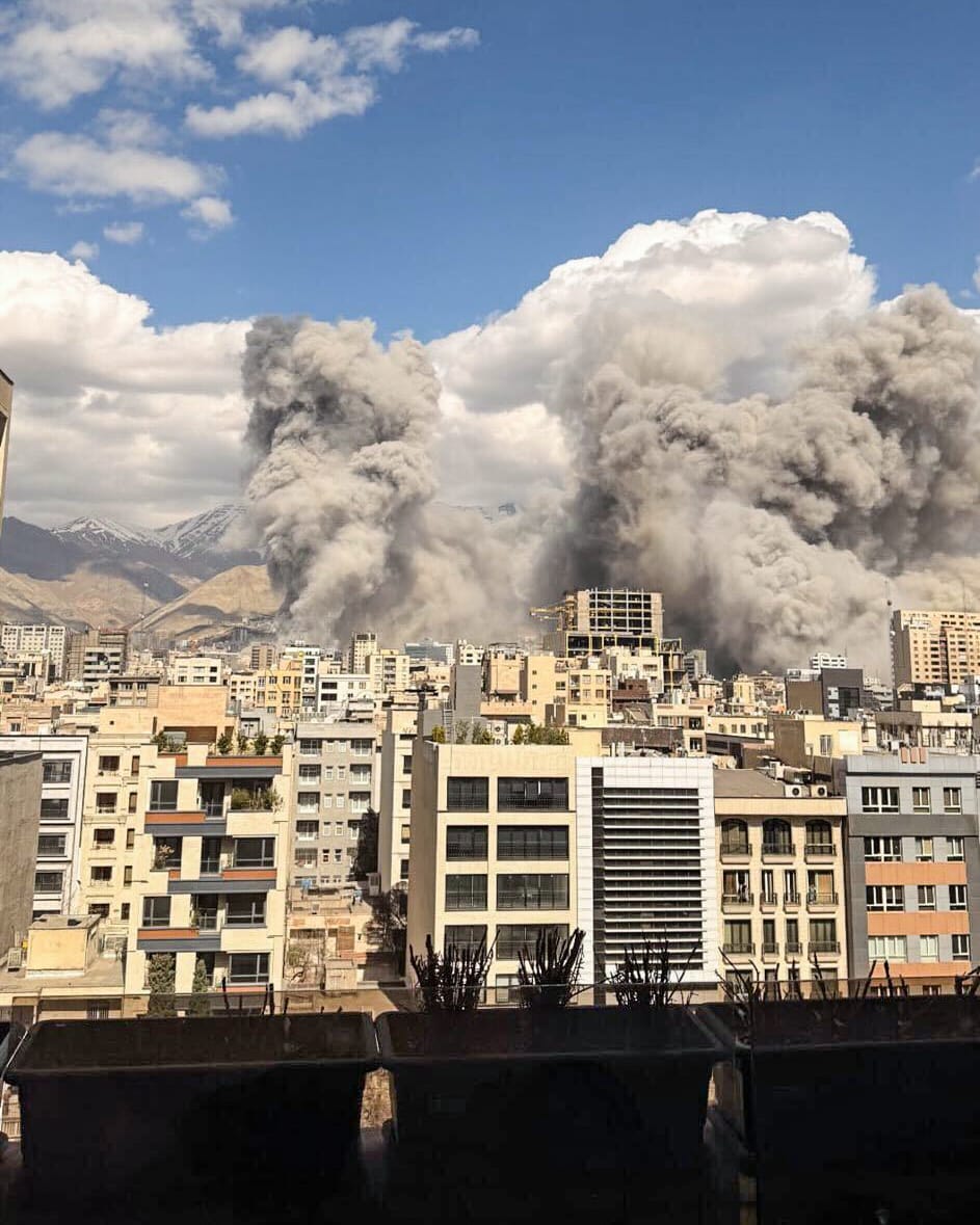 Smoke plumes above buildings in the distance