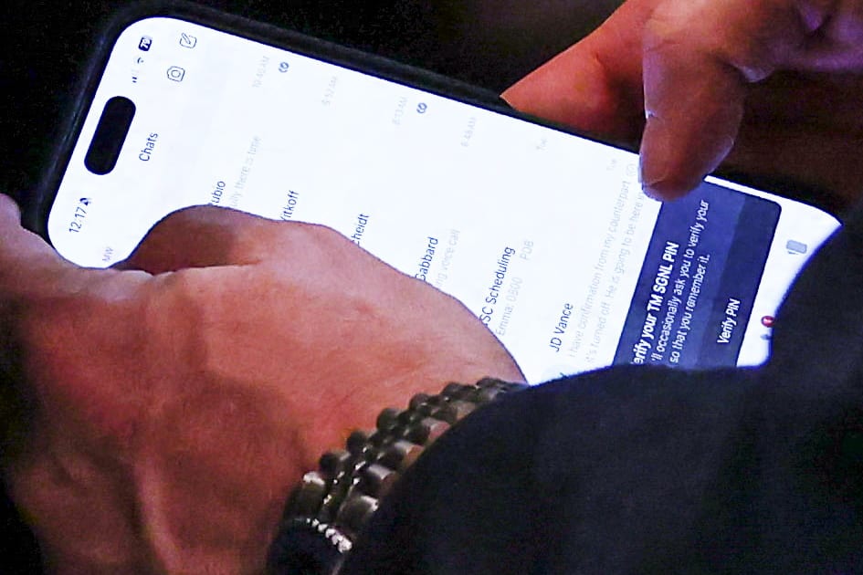 Mike Waltz checks the Signal app on his phone