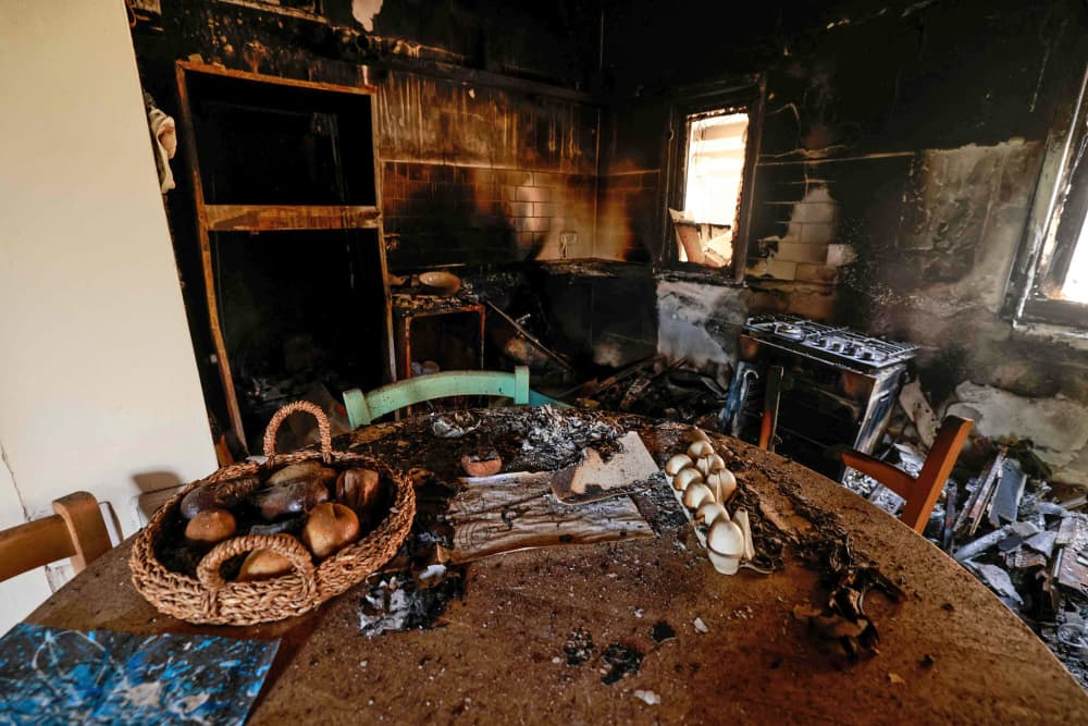 A picture taken during a media tour organized by the Israeli military shows food on a table inside a burned house in the kibbutz Nir Oz along the border with the Gaza Strip on Oct. 19, 2023. The kibbutz was attacked on Oct. 7 by Hamas militants.