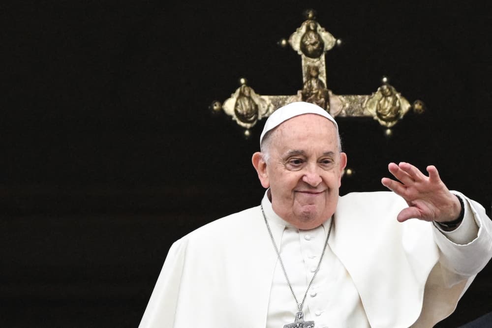 Pope Francis waves from the central loggia of St. Peter's basilica