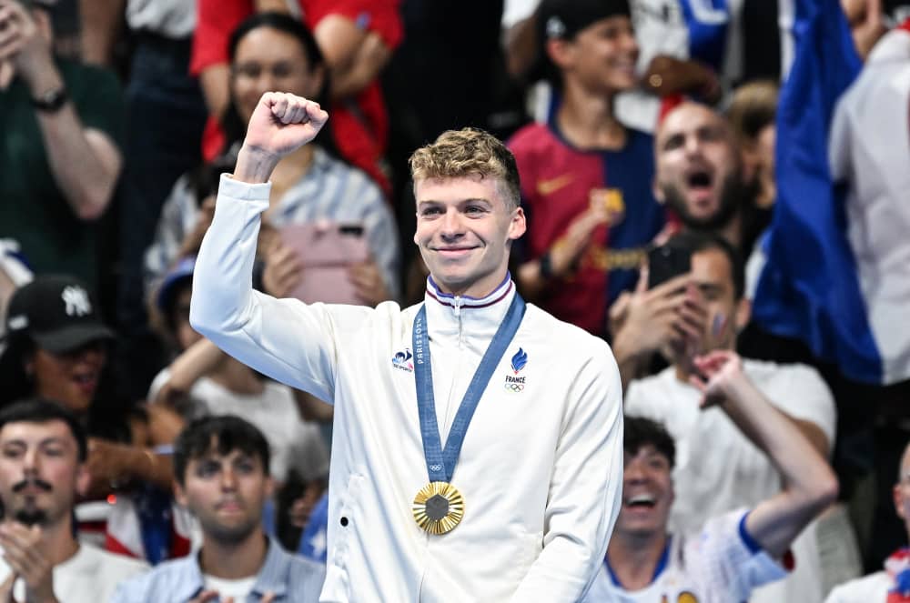 Leon Marchand raises a fist