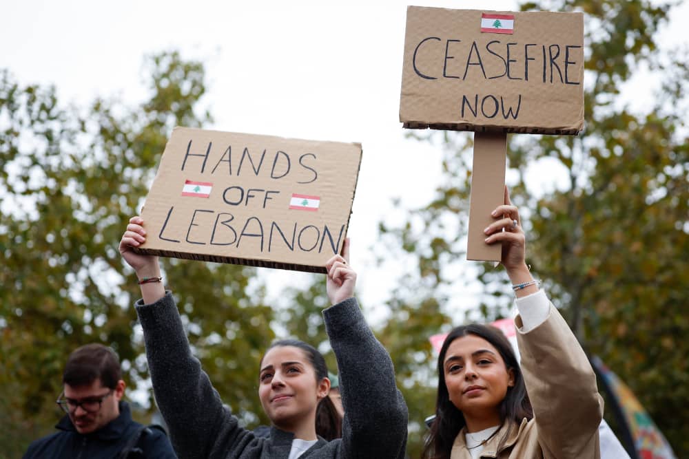Protestors hold signs saying "Hands off Lebanon" and "Ceasefire Now"