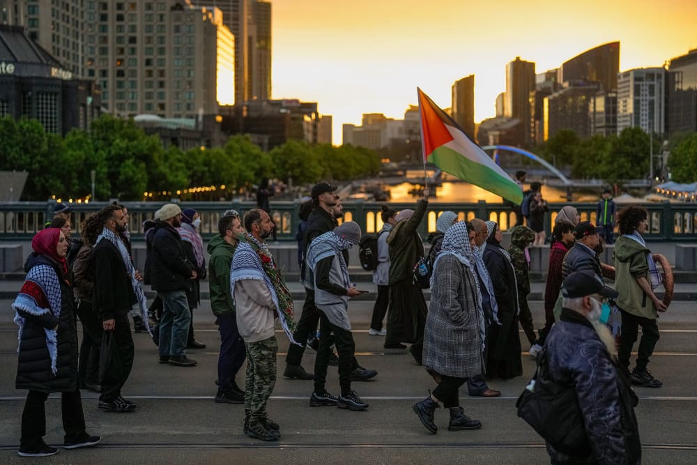A protesters holds a Palestinian flag during a march on Oct. 7, 2024 in Melbourne, Australia, to honor victims of the war in Gaza.