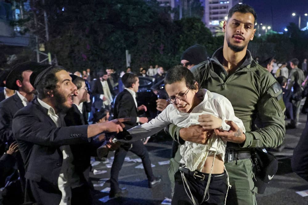 Members of Israeli security forces remove ultra-Orthodox Jewish demonstrators