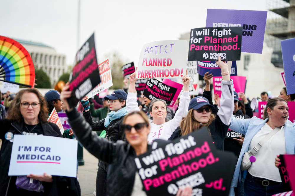 Protestors hold signs in support of Planned Parenthood
