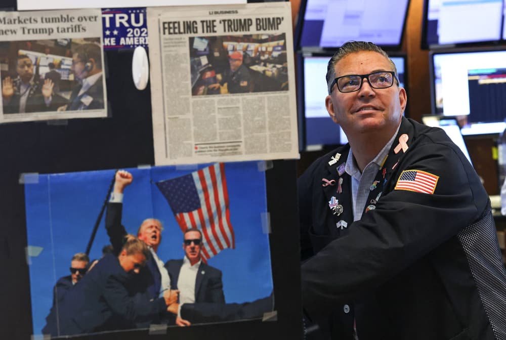 Newspaper clippings and an image of President Donald Trump are displayed on a desk as traders work on the floor of the New York Stock Exchange on April 9, 2025.