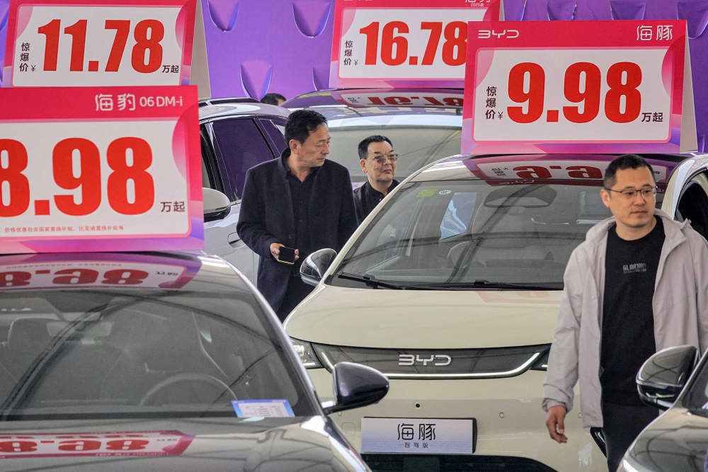 Customers look at BYD electric cars at an auto show in Yantai, China on April 10, 2025.