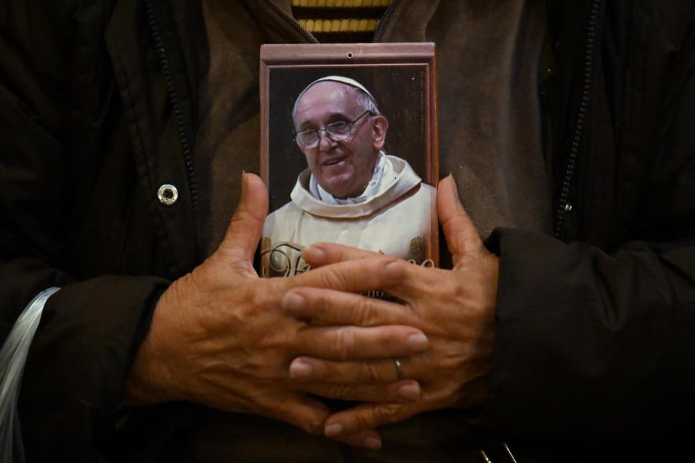 A faithful Catholic holds a portrait of Pope Francis as she attends Mass at the Basilica San Jose de Flores in Buenos Aires on April 21, 2025.