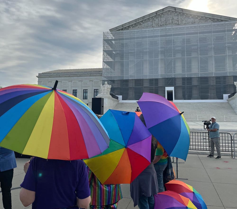 Activists carry rainbow umbrellas outside the Supreme Court on April 21, 2025.