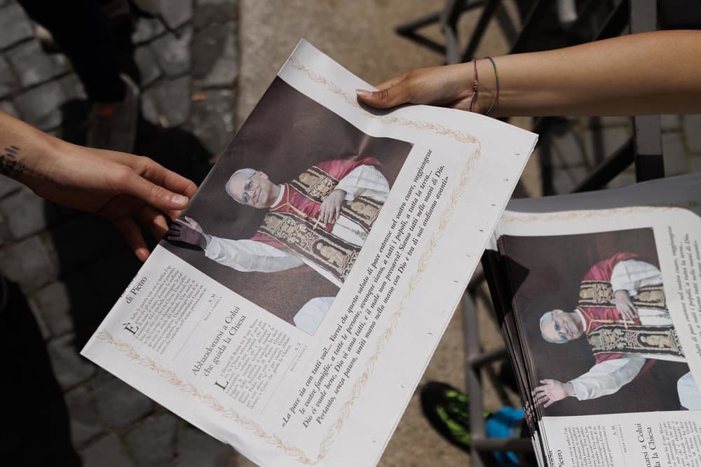 People rush to grab some of the first copies of the Vatican Newspaper 'L'Osservatore Romano' on May 9, 2025 in Vatican City.
