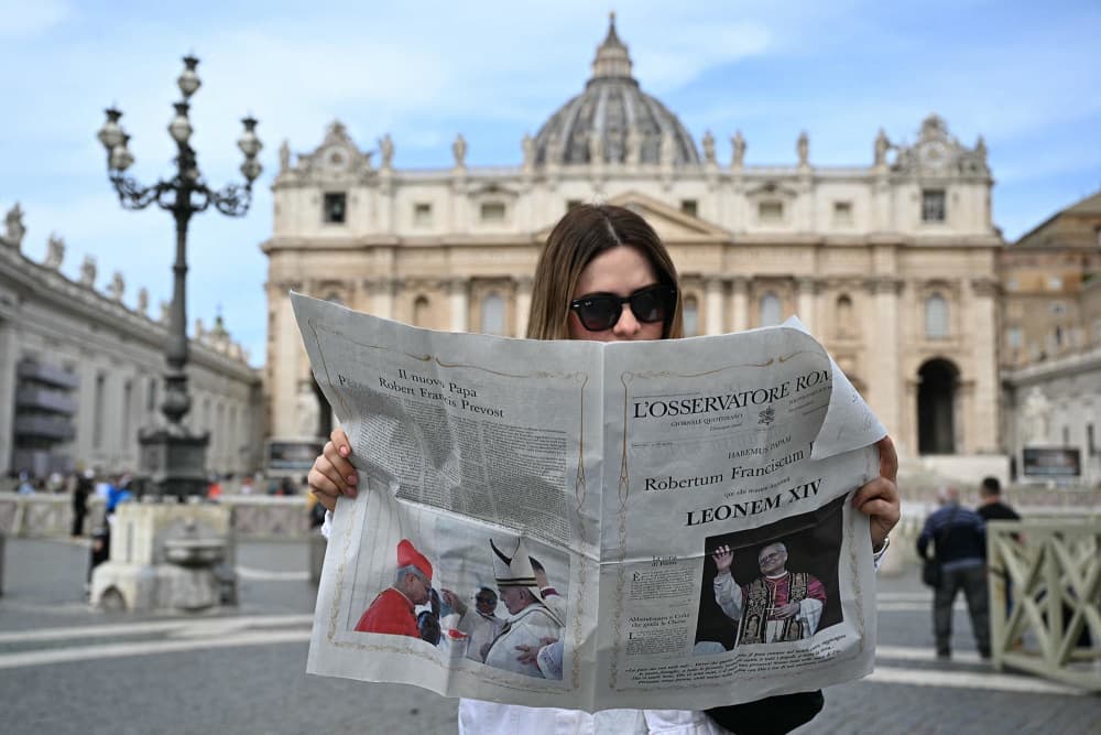 A woman reads L'Osservatore Romano newspaper in St Peter's Square 