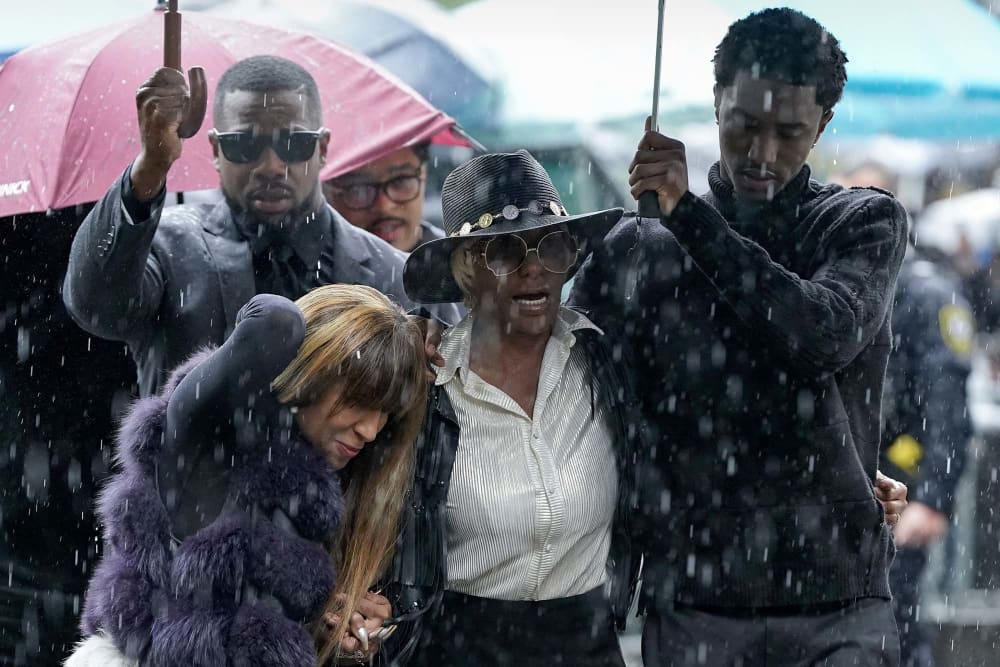 King Combs, son of Sean Combs, holds an umbrella for Janice Combs, mother of Sean Combs, as they arrive at federal court for Sean "Diddy" Combs' sex trafficking trial in New York City on May 14, 2025.