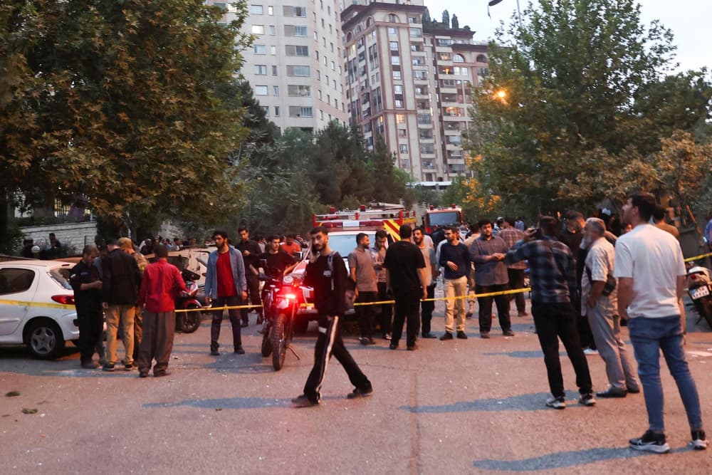 People gather in the street in Tehran in the aftermath of Israeli strikes on June 13, 2025. 