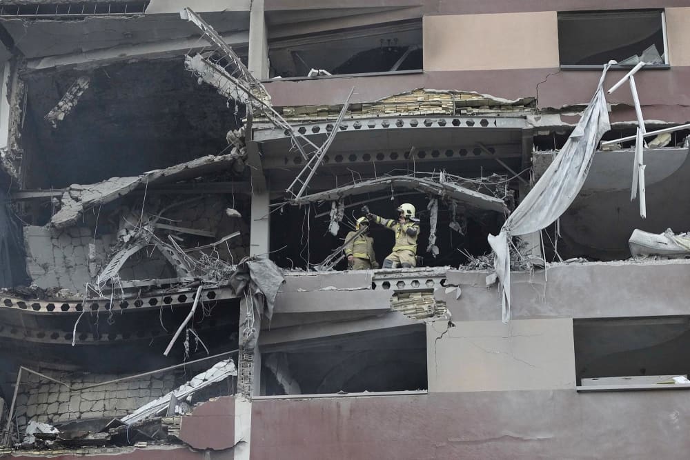 Firefighters work at the scene of an explosion at an apartment building in Tehran