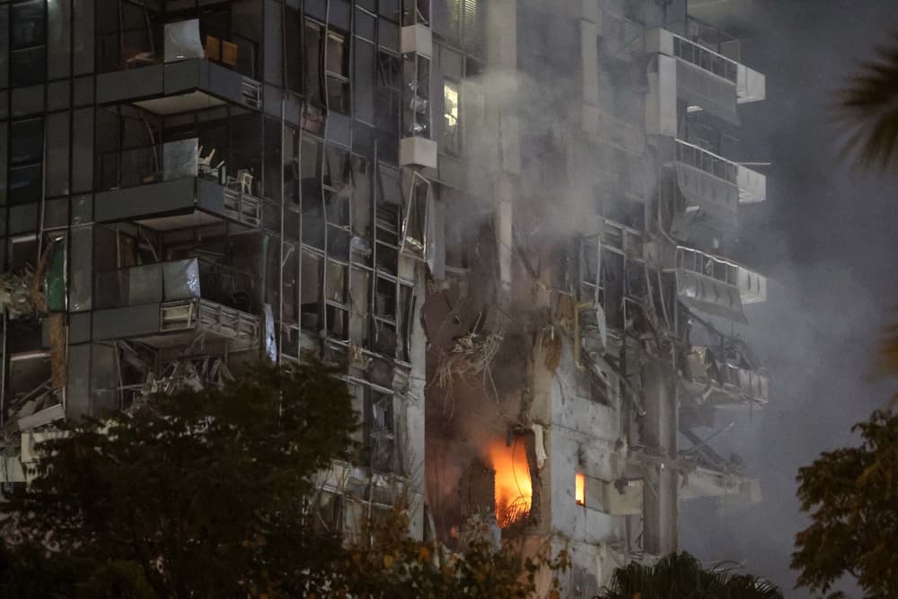 Fire and smoke rise from a building, reportedly hit by a missile fired from Iran, in central Tel Aviv on June 13, 2025.