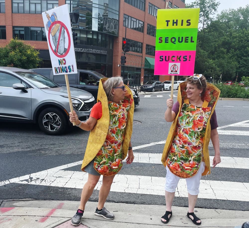 Demonstrators in taco costumes hold "No Kings" protest signs in Washington, D.C., on June 14, 2025.