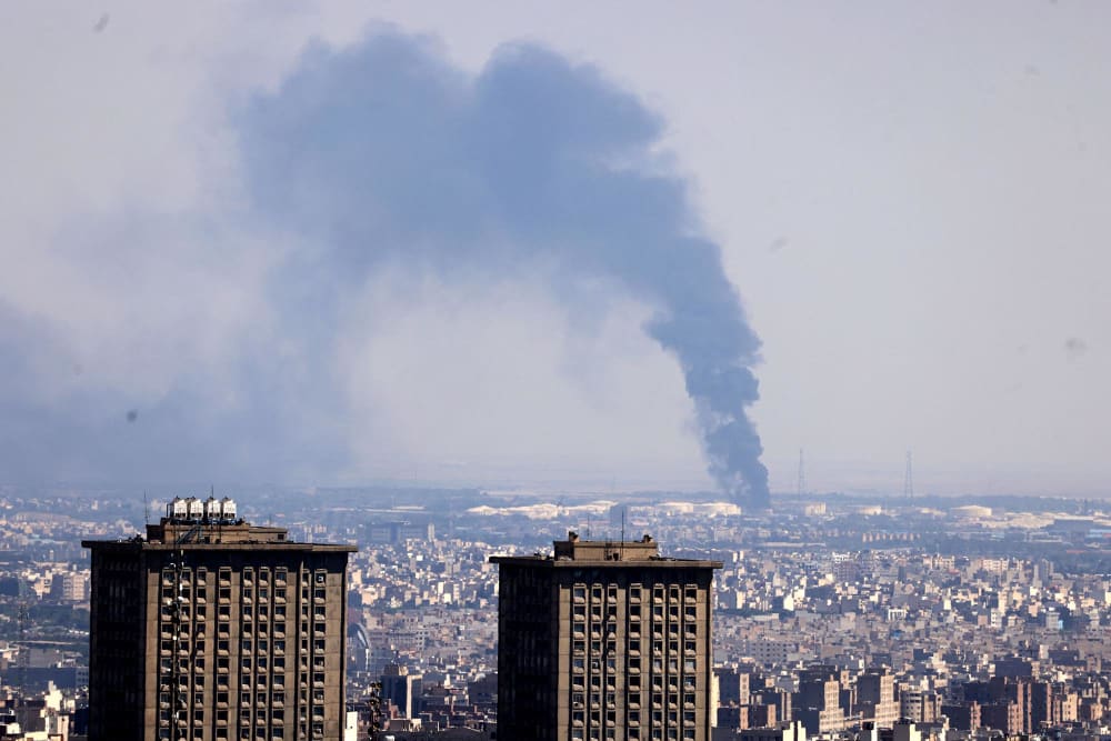 Smoke billows in the distance from an oil refinery following an Israeli strike on the Iranian capital Tehran on June 17, 2025.