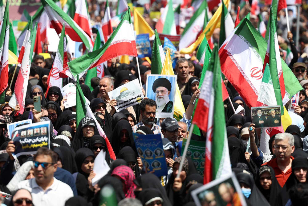 Iranians wave their national flag and wave placards during an anti-Israeli rally in Tehran on June 20, 2025.