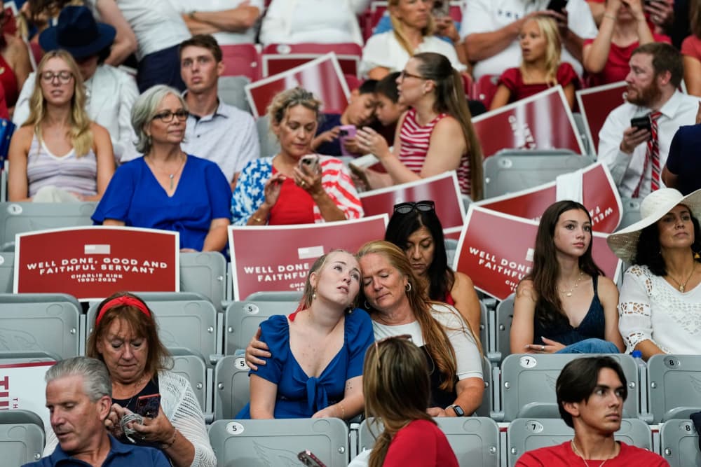 People sit on seats in a stadium