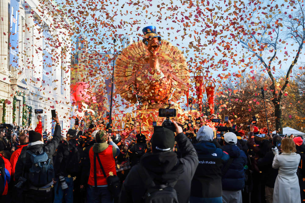 Confetti is released outside as a giant Turkey float passes by