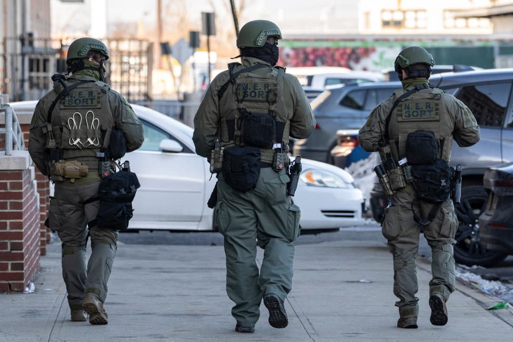Three federal officer walks outside on a sidewalk