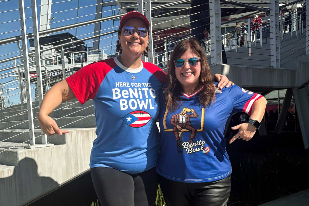Two women stand next to each other wearing "Benito Bowl" t-shirts