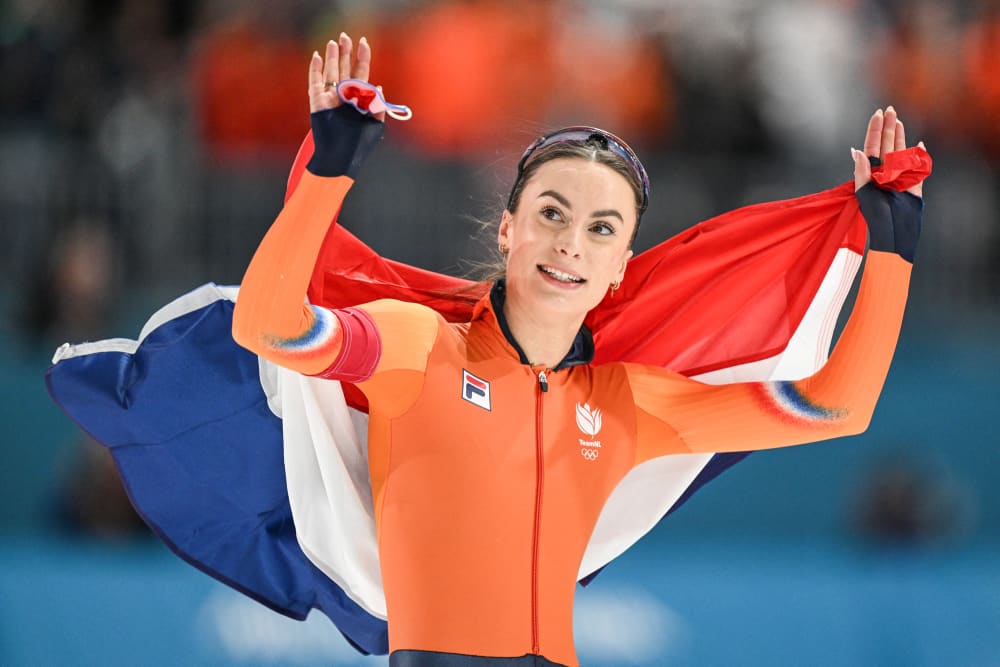 Femke Kok holds a Netherlands flag behind her in celebration
