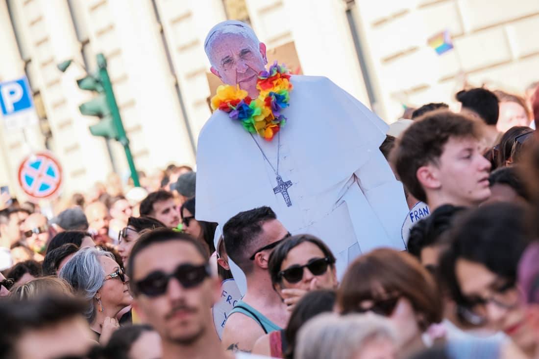 A sign with a silhouette of Pope Francis wearing a rainbow