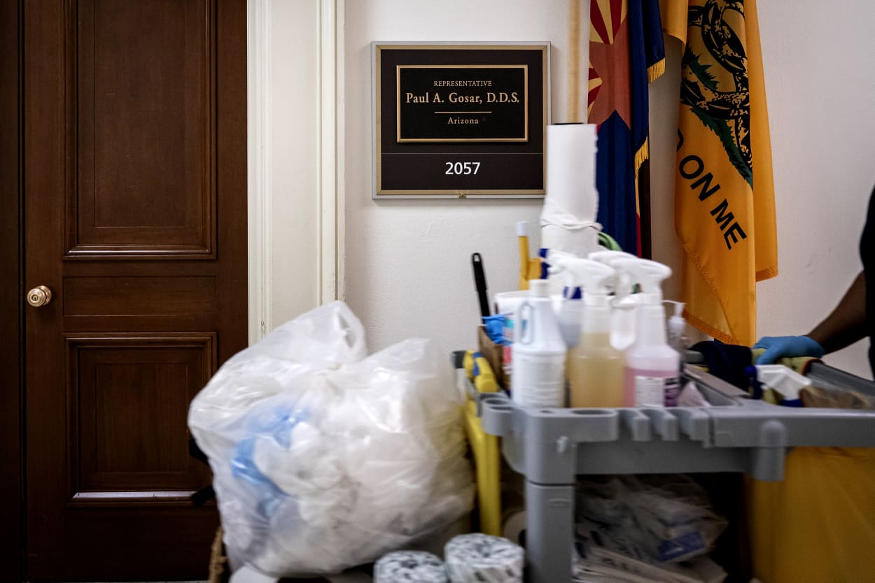 Image: A custodian walks past the office of Rep. Paul Gosar, R-Ariz., who is voluntarily quarantining after interacting with a person who has coronavirus, on Capitol Hill on Monday.