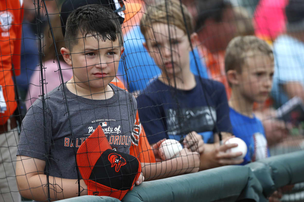 Image: Young fans looking for autographs react with disappointment after being told by a baseball player that he couldn't sign, prior to a spring training baseball game between the Baltimore Orioles and the Atlanta Braves