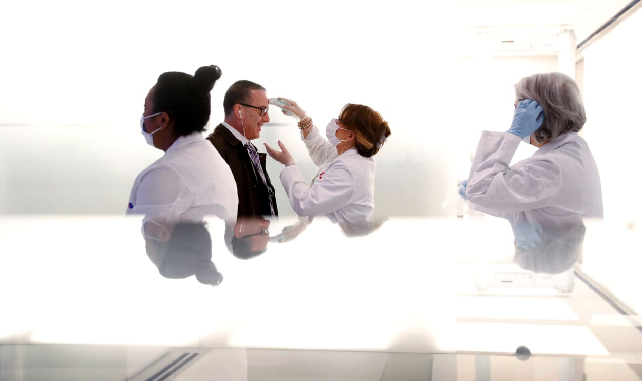 Image: Employees entering the New York Stock Exchange are screened for fever on Tuesday.