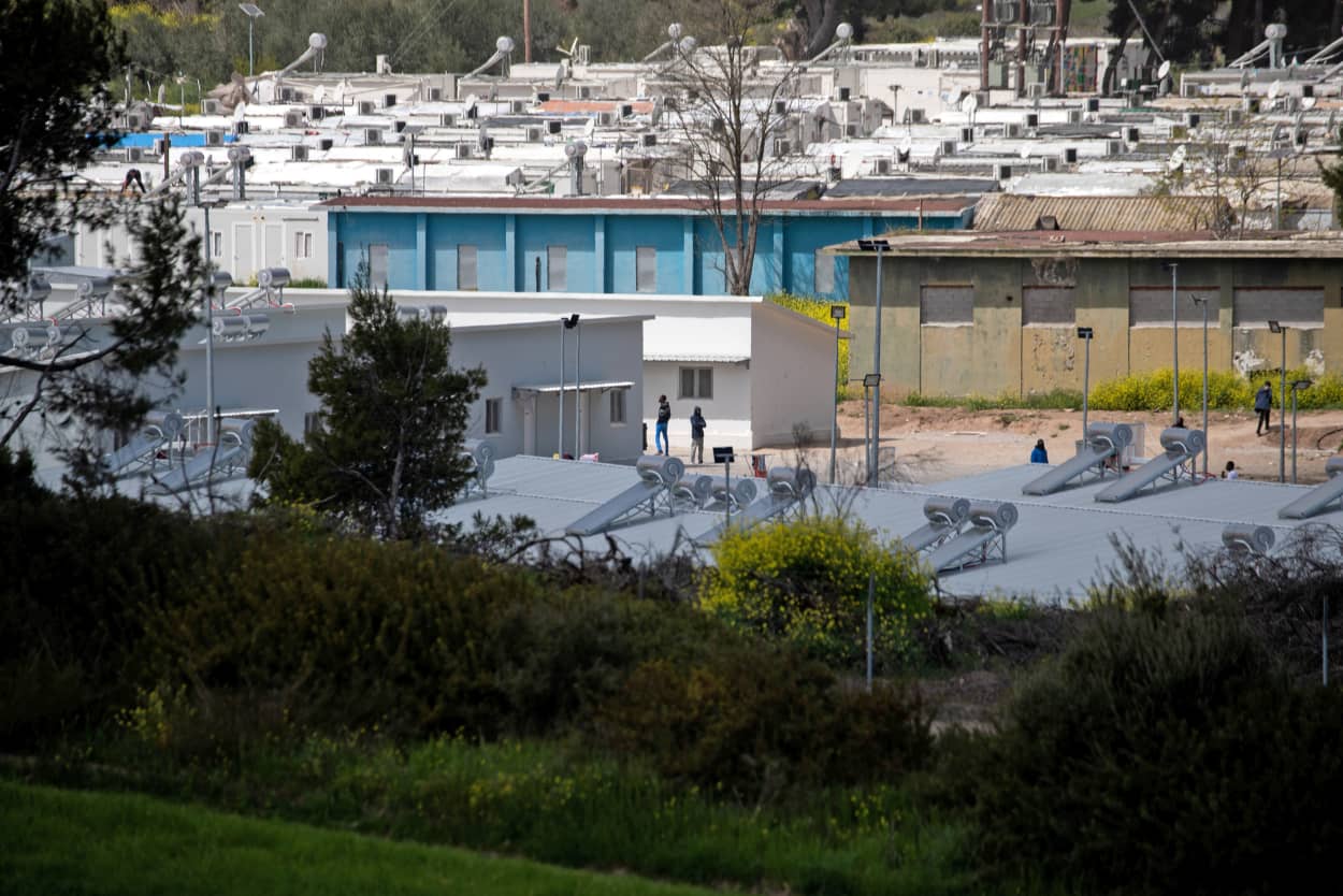 Migrants make their way in the Ritsona migrant camp after authorities found 20 coronavirus cases and placed the camp under quarantine, following the outbreak of coronavirus disease (COVID-19), in Ritsona