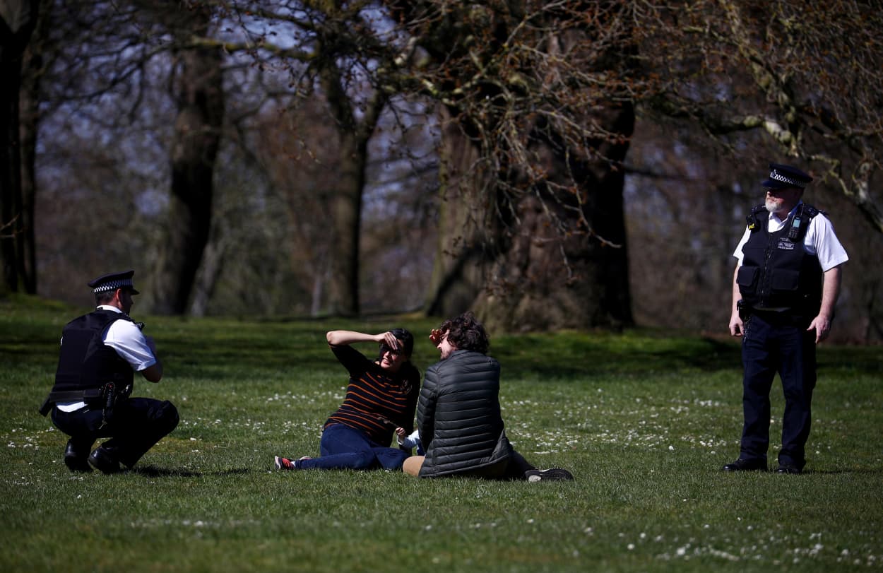 Image: Police officers speak with people at Greenwich Park in London on April 4, 2020.