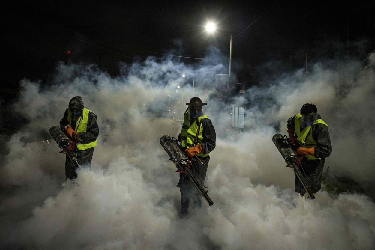 Image: Volunteers fumigate a street in a residential area of Nairobi to curb the spread of coronavirus on Monday.
